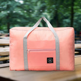 A large, rectangular peach-colored duffel bag with gray straps and a front zippered pocket rests on a wooden surface