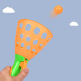 Red and yellow plastic catapult ball toy with a ball
