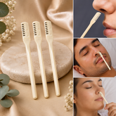 Three beige manual nose hair trimmers stand upright on a light brown stone surface with white flowers.