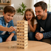 A boy pulls a numbered wooden block from a tall tower as his father and sister watch with excitement.