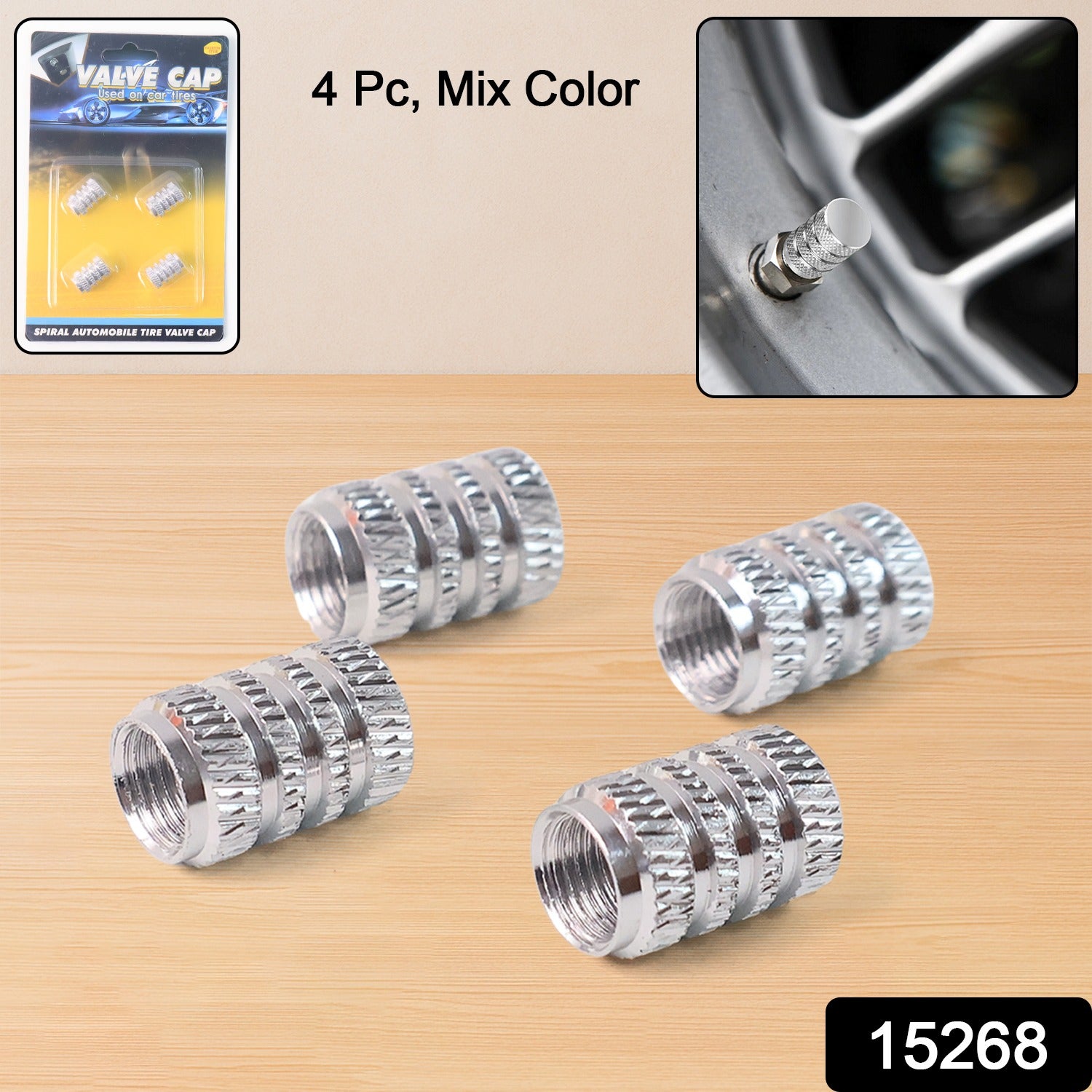 Four shiny silver metal valve caps with textured grip bands displayed on a wooden surface.