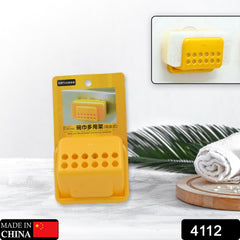 Yellow plastic sponge holder in packaging, with an inset image showing it holding a white sponge on a wall.