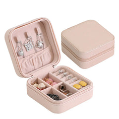 Open pink jewelry box filled with different accessories, with a closed box behind it.
