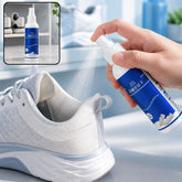 A hand sprays white mist from a blue and white bottle into a light gray athletic shoe. An inset shows the bottle on a shelf.