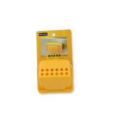 The back of a yellow plastic sponge holder with a clear suction cup, beside a lotion bottle and open jar.