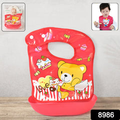 A red plastic baby bib with a yellow teddy bear and cupcake design, featuring a deep food-catching pocket.