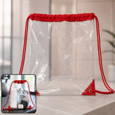 Transparent drawstring bag with red fabric top and cords, shown on a counter with a smaller inset image of it holding items.