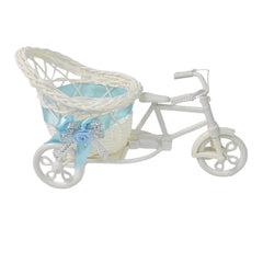 White plastic decorative tricycle with a woven basket featuring a light blue ribbon and silver embellishments.
