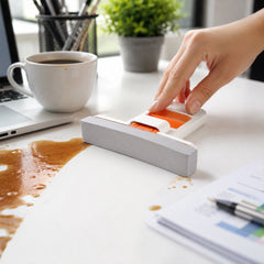 The white and orange mini sponge mop is shown from the front, featuring a grey, ridged sponge head on a plain white