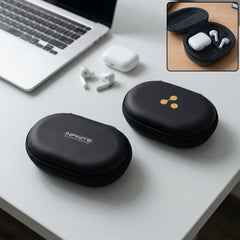 Two black oval earbud cases on a white desk, one with text, the other with a gold logo, near a laptop.