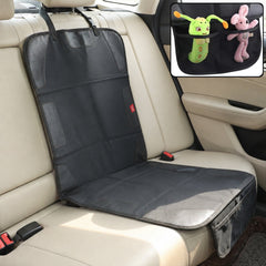 The car seat protector is shown in a cream-colored car interior, with a small red label visible on the backrest portion.