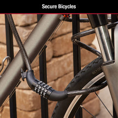 Black braided steel cable lock securing a bicycle frame to a metal rack outdoors.