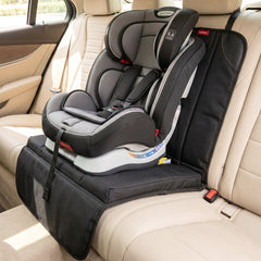A gray and black child car seat sits atop the protector, which is installed in a beige leather car.