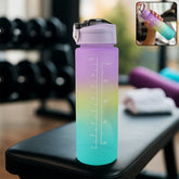 A tall, ombre water bottle with purple, yellow, and blue hues sits on a gym bench, showing measurement lines.