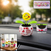 A winking emoji face flower in a heart-patterned pot on a car dashboard, with insets showing other designs and a solar panel.
