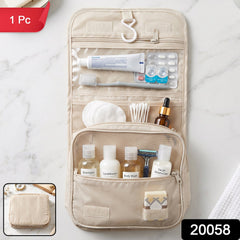 A beige foldable toiletry bag hangs open, displaying various travel-sized personal care items in its mesh and clear