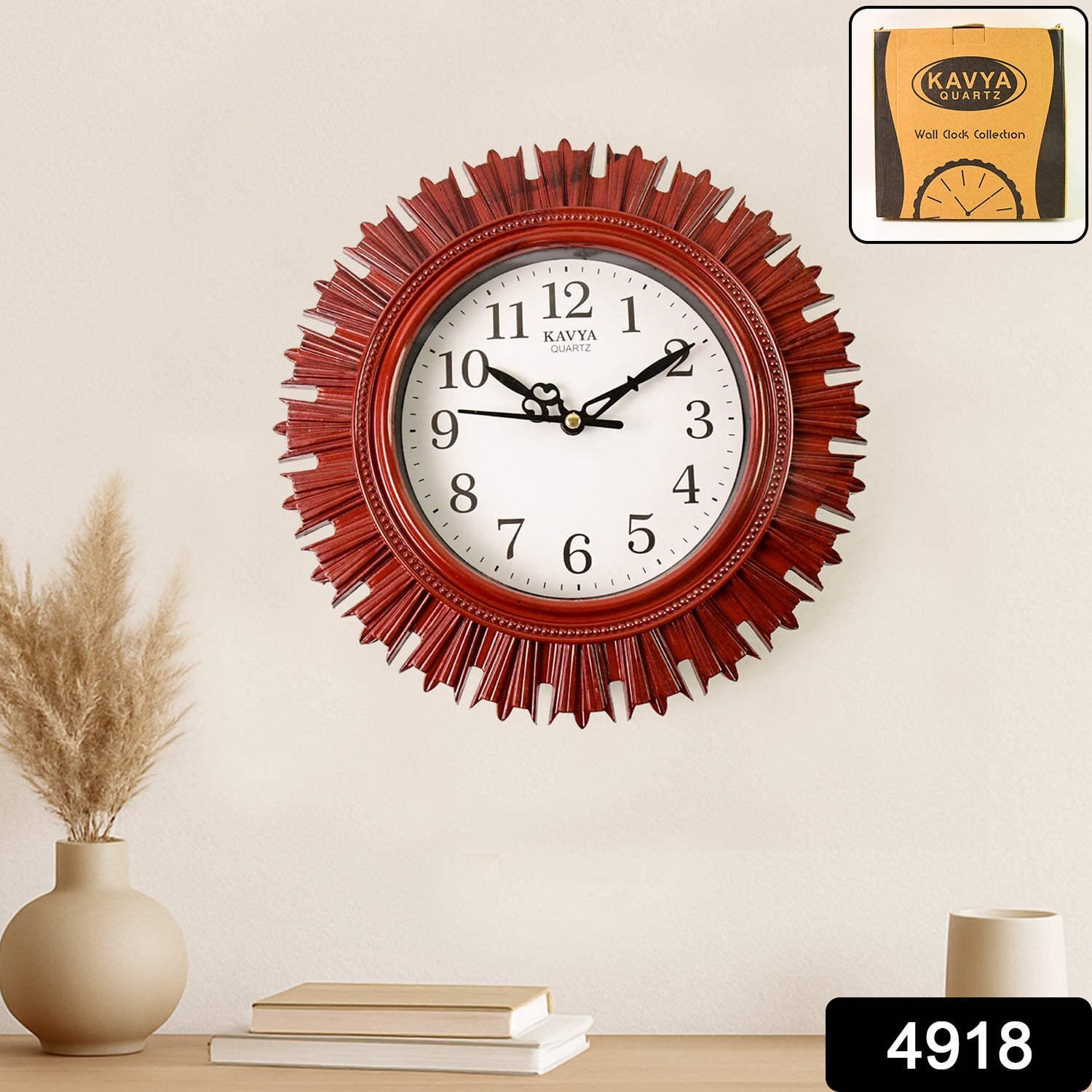Red sunburst wall clock with white face and black numbers, displayed on a light wall above a vase and books.