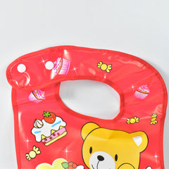 Close-up of the top portion of a red baby bib, showing the snap closure and scattered candy illustrations.