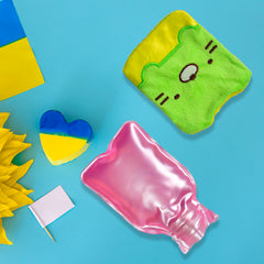 A green and yellow kitty hot water bag with a pink bottle, next to a Ukrainian flag.