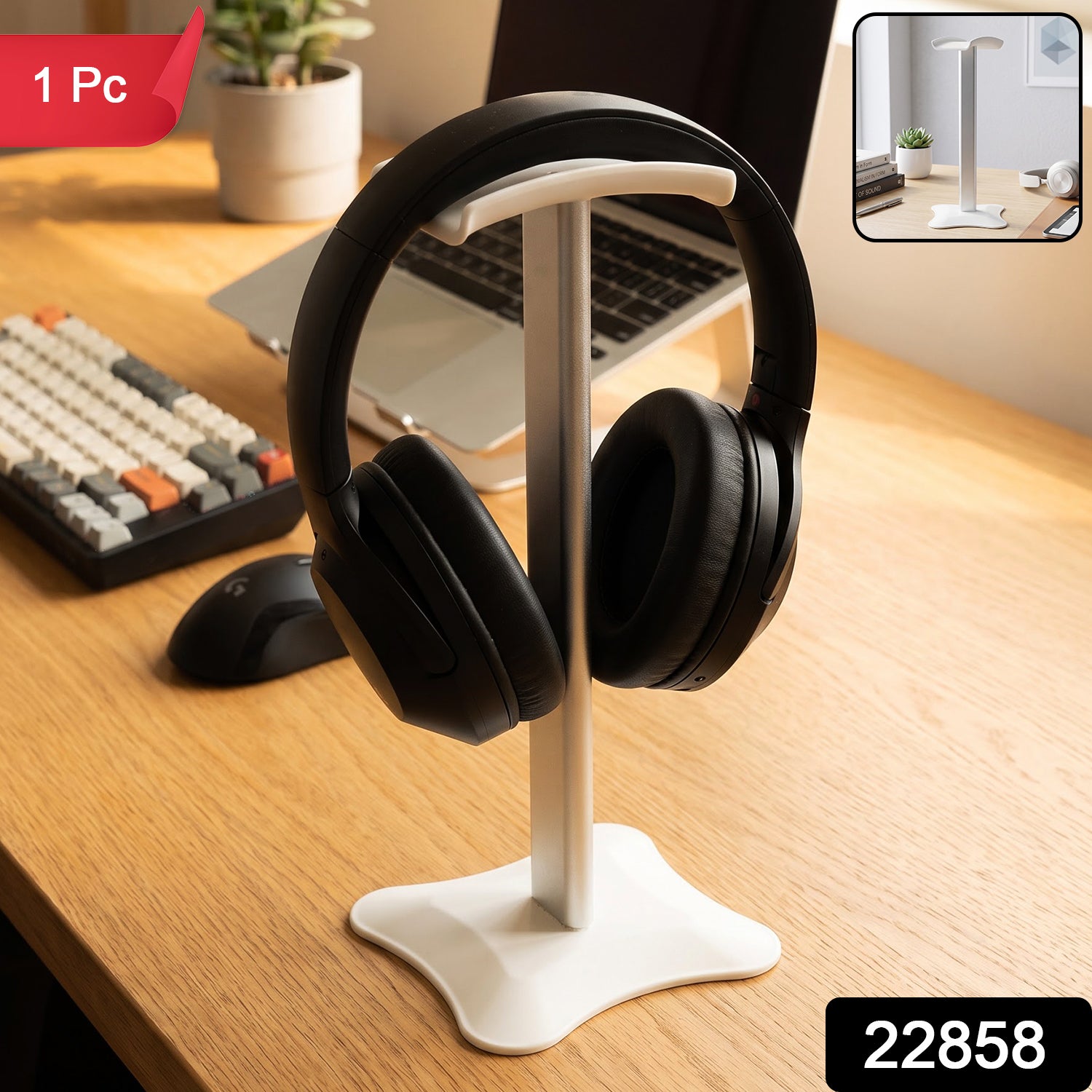 White metal headphone stand with black headphones on a wooden desk with a laptop and keyboard.