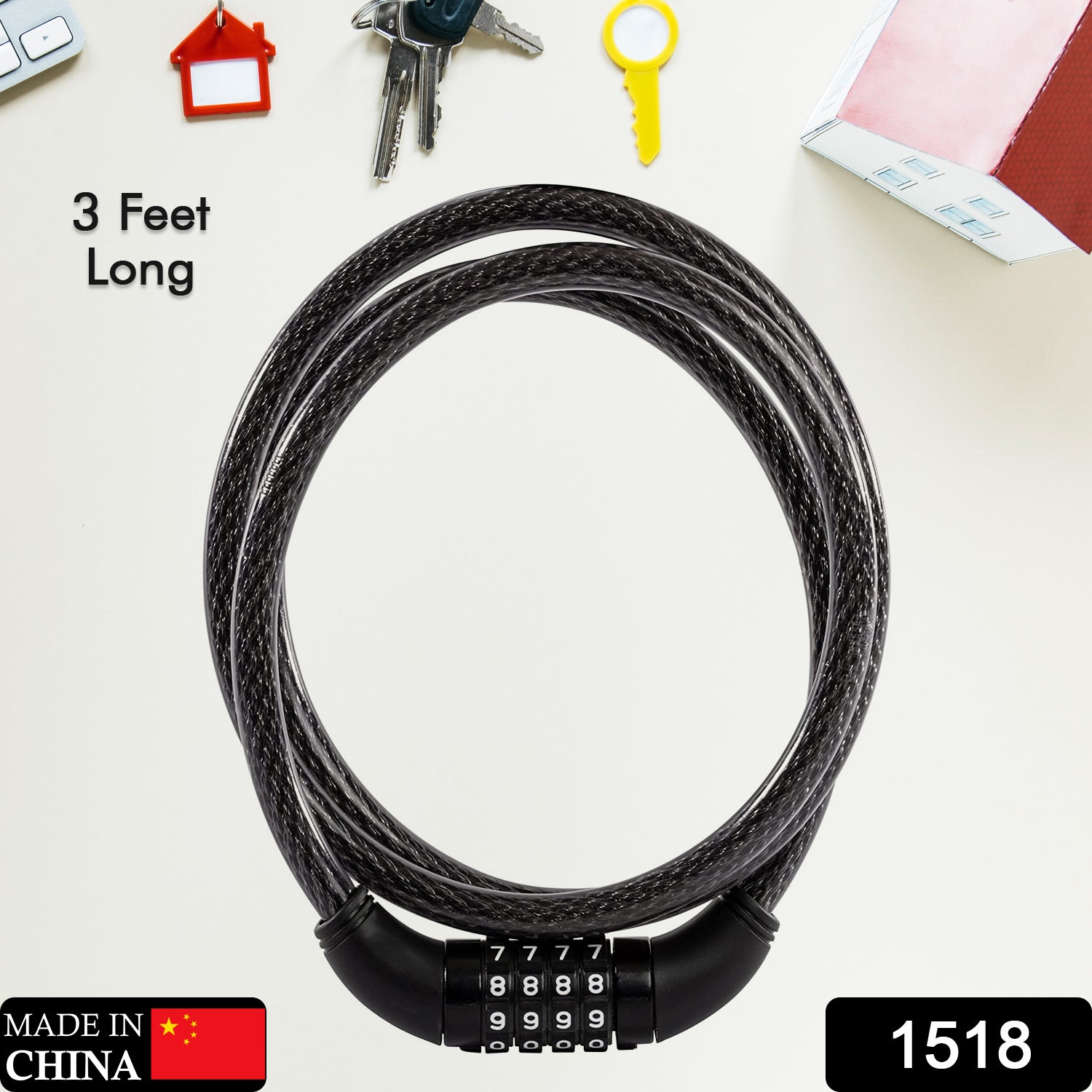 Black braided steel cable lock with a four-digit combination dial, coiled on a desk with keys and a notebook.