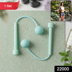 A mint green cordless jump rope with two weighted balls and handles lies on a textured green surface.