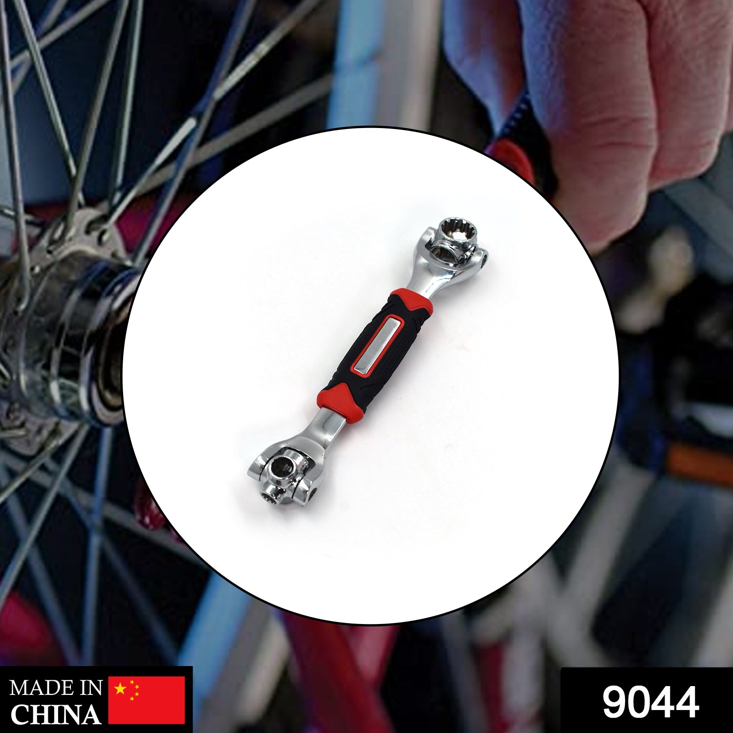 A chrome universal wrench with red and black handle is centered on a blurred background of a bicycle wheel.