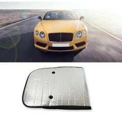 A folded silver car sunshade with black trim and two suction cups, with a yellow sports car driving on a road in the