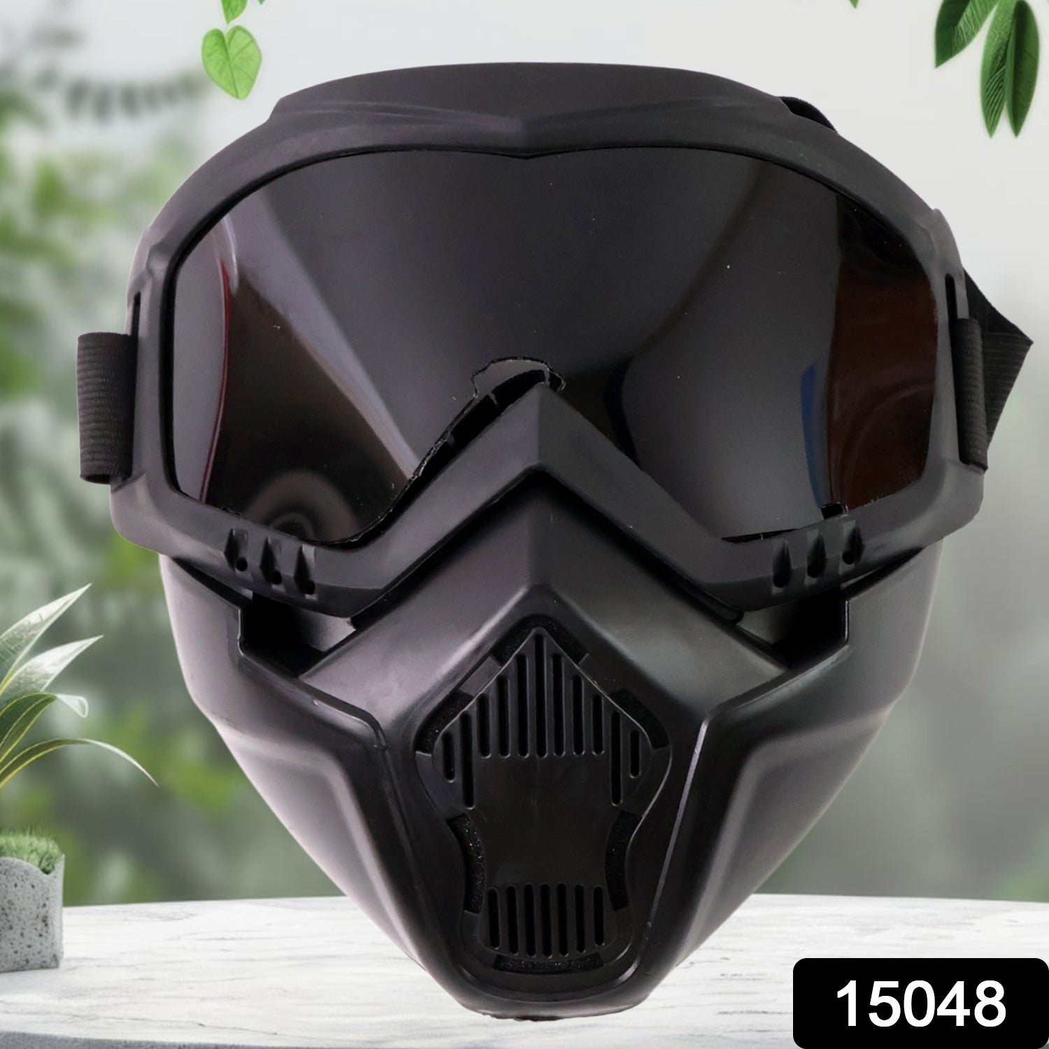 Black motorcycle goggles with a dark tinted lens and an attached face mask with ventilation details.