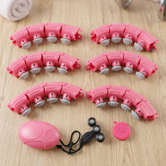 Several curved pink segments of a hula hoop, a pink weighted ball, and a small black wheeled component are displayed on a