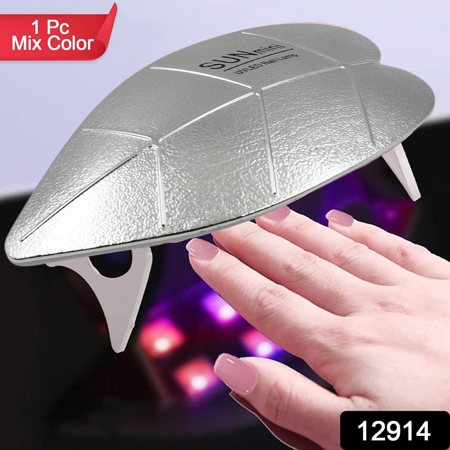 A silver leaf-shaped UV LED nail lamp illuminates a hand with light pink polished nails.
