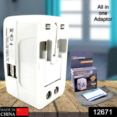 White universal travel adapter with its box, instruction booklet, and a gray pouch on a wooden surface.