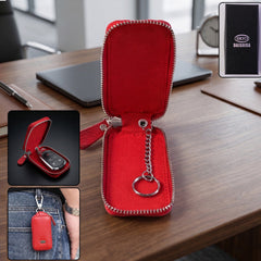 A vibrant red leather key case, unzipped to reveal an internal chain and ring, rests on a dark wooden surface with office