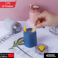 A hand fills a blue dispenser base with toothpicks, next to a grey and a pink dispenser, with their lids removed.