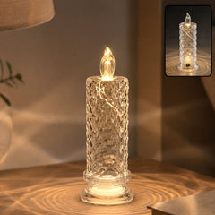 A clear faceted crystal LED candle light glowing warmly on a wooden surface, casting patterned light.