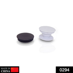 A black collapsed phone grip sits next to an expanded white phone grip on a white surface.