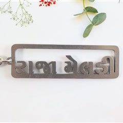 Gujarati text metal keychain featuring devotional design