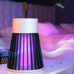A black and white Mosquito Killer Lamp with purple light sits on a white table in a bedroom with flying mosquitoes.