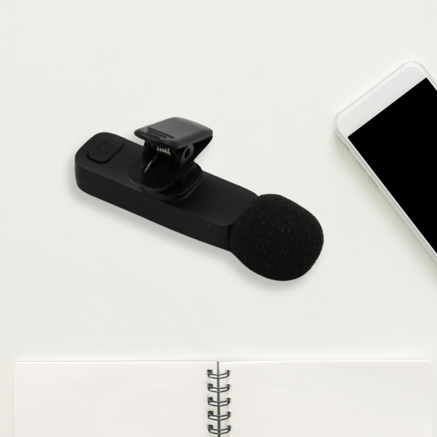 Wireless lapel microphone shown with its charging port and universal compatibility.