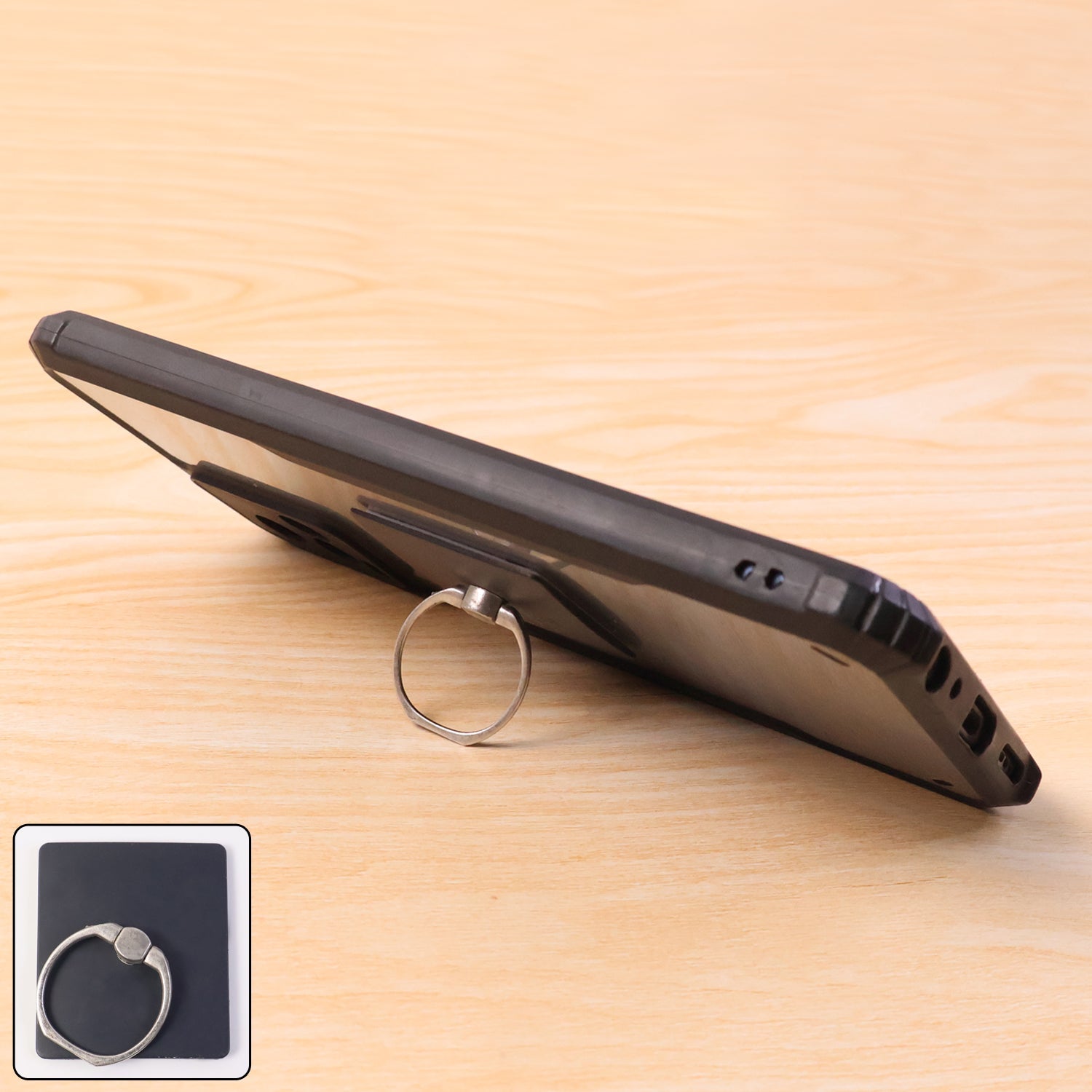 Black smartphone propped up on a wooden surface using a silver ring holder, with an inset showing the product.