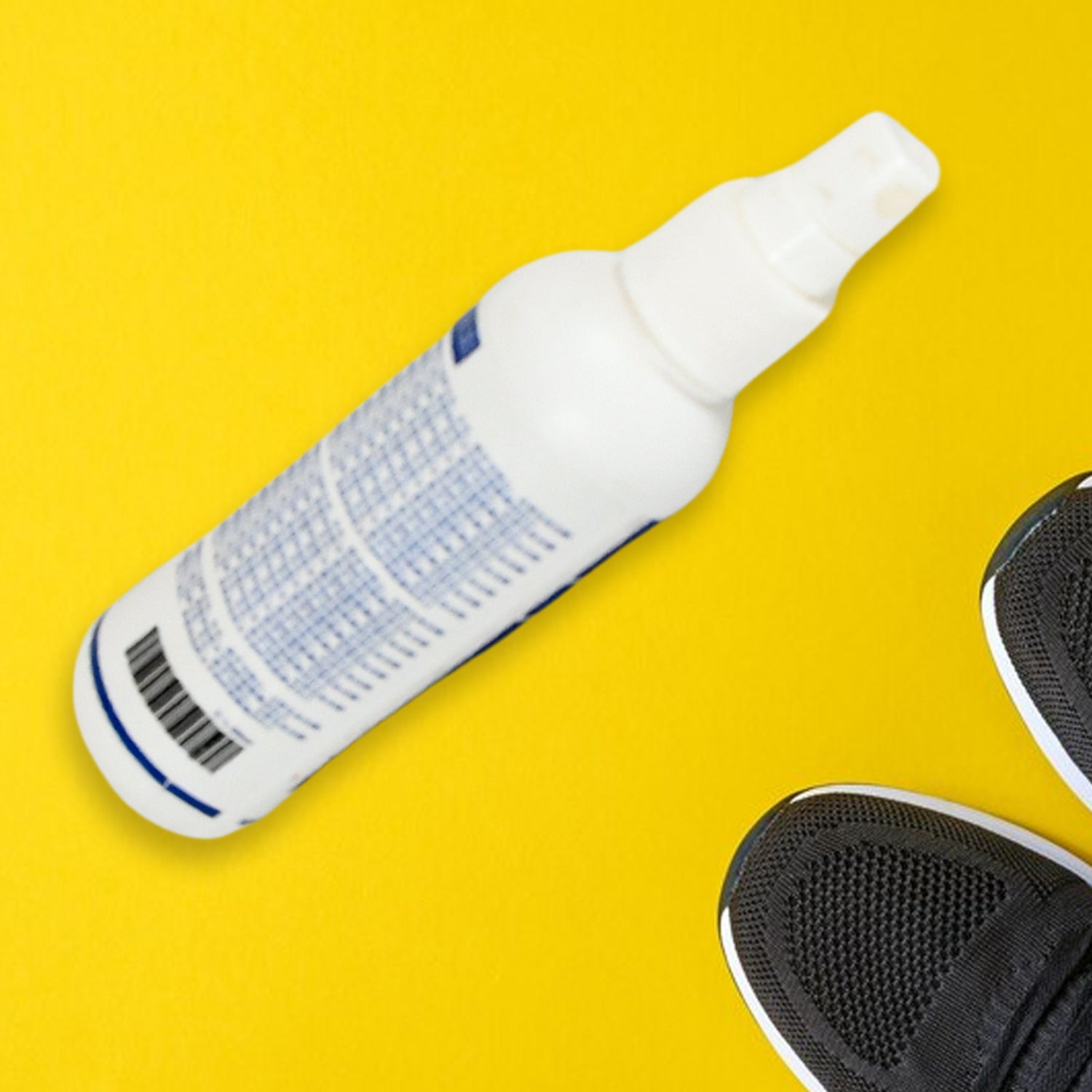 A white and blue bottle of shoe and sock deodorant lies diagonally on a bright yellow background, with the toes of black