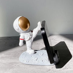 Astronaut Phone Holder with a phone, demonstrating its stable and secure base.