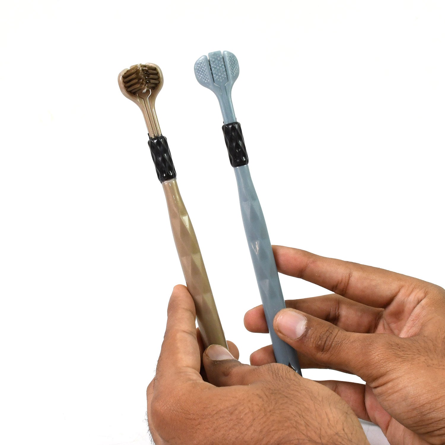 A pair of hands holding a beige and a blue three-sided toothbrush against a white background.