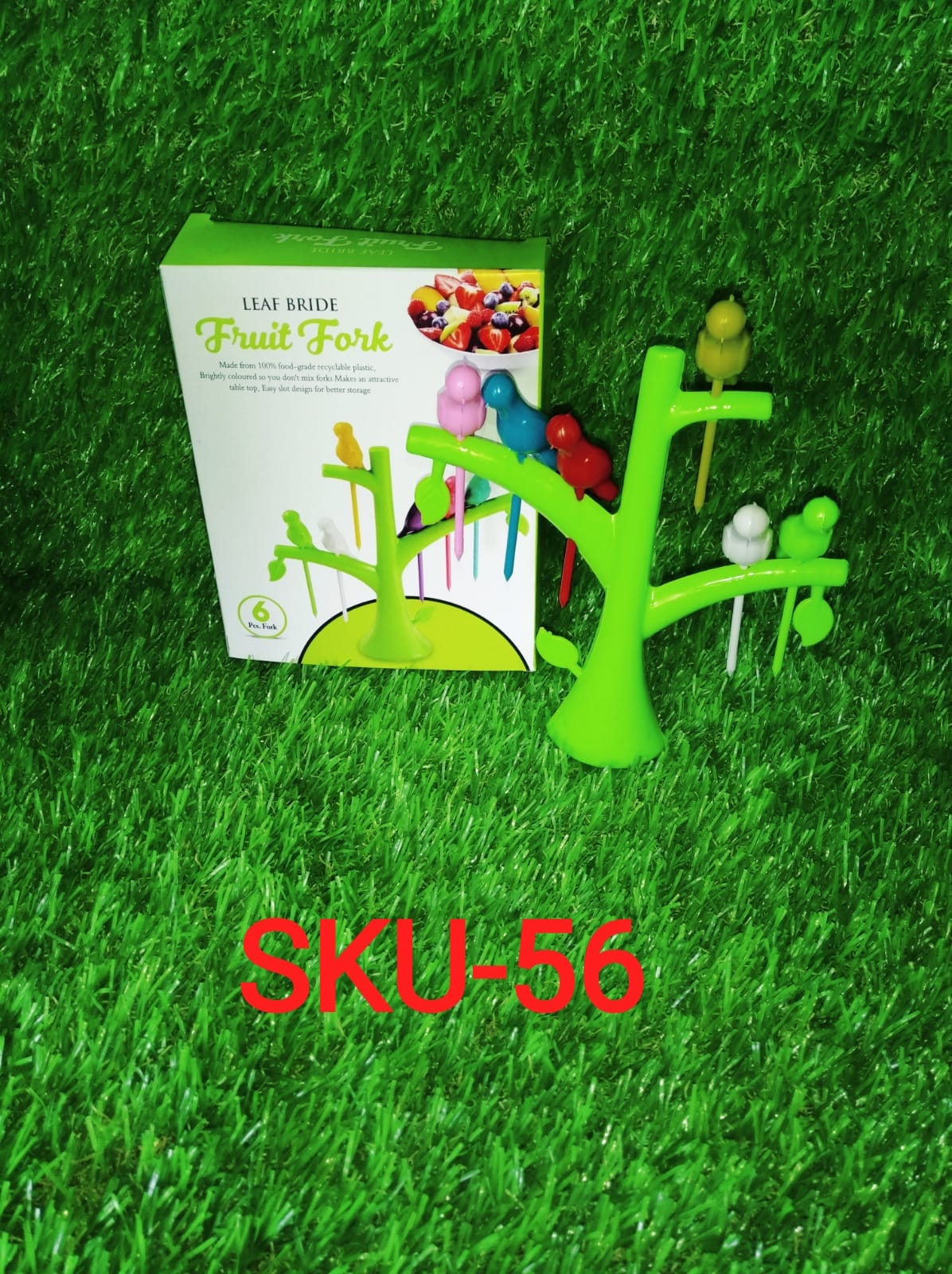Different coloured bird fruit forks arranged decoratively on a plate with fresh fruits.