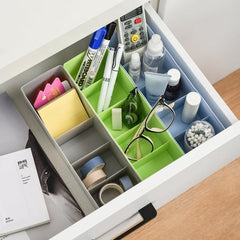 Clear plastic organizer box with sections holding colourful beads and craft supplies.