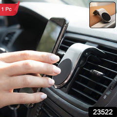 A close-up of the silver and black magnetic car phone holder on a brown textured surface.