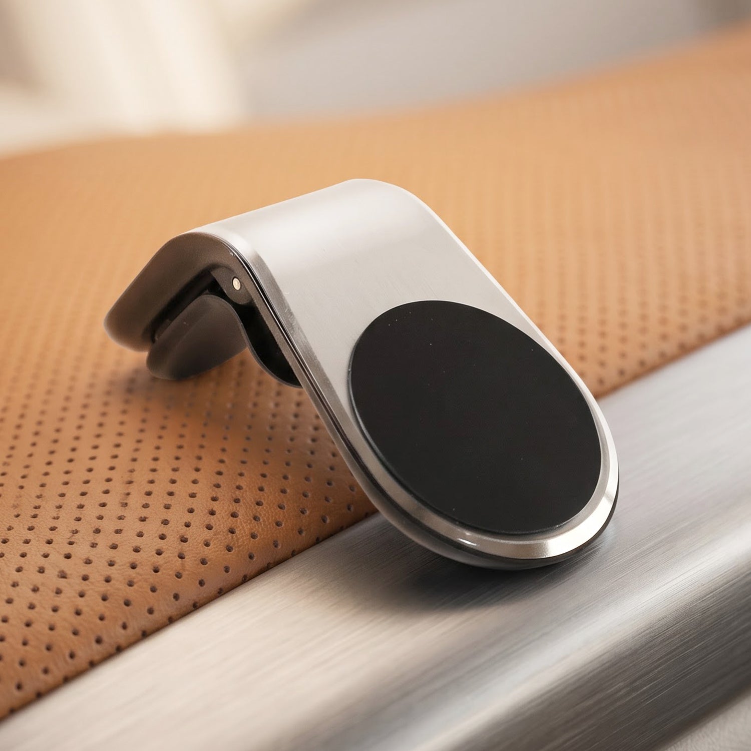 A silver and black magnetic car phone holder is shown with its dimensions, 7 cm by 4 cm.