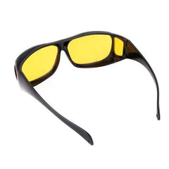 A single pair of black wrap-around glasses with yellow lenses, viewed from the top-right, on a white background.