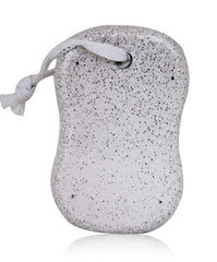 A grey, porous pumice stone with a white rope attached, casting a reflection on a white surface.
