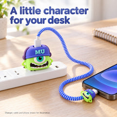 Green Mike Wazowski charger cover with a blue cable protector connected to a phone on a wooden desk.